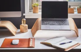 Biurko z laptopem, moniktorem i innymi akcesoriami pracy biurowej